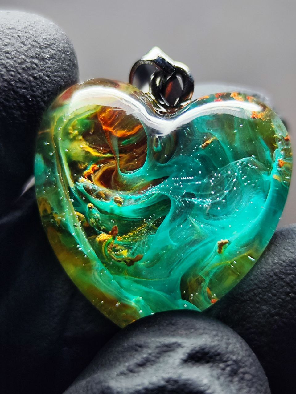 Magic jewelry space hearts made of epoxy resin and alcohol ink.
