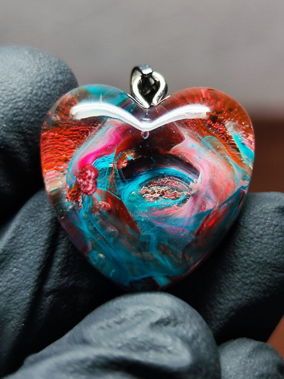 Magic jewelry space hearts made of epoxy resin and alcohol ink.