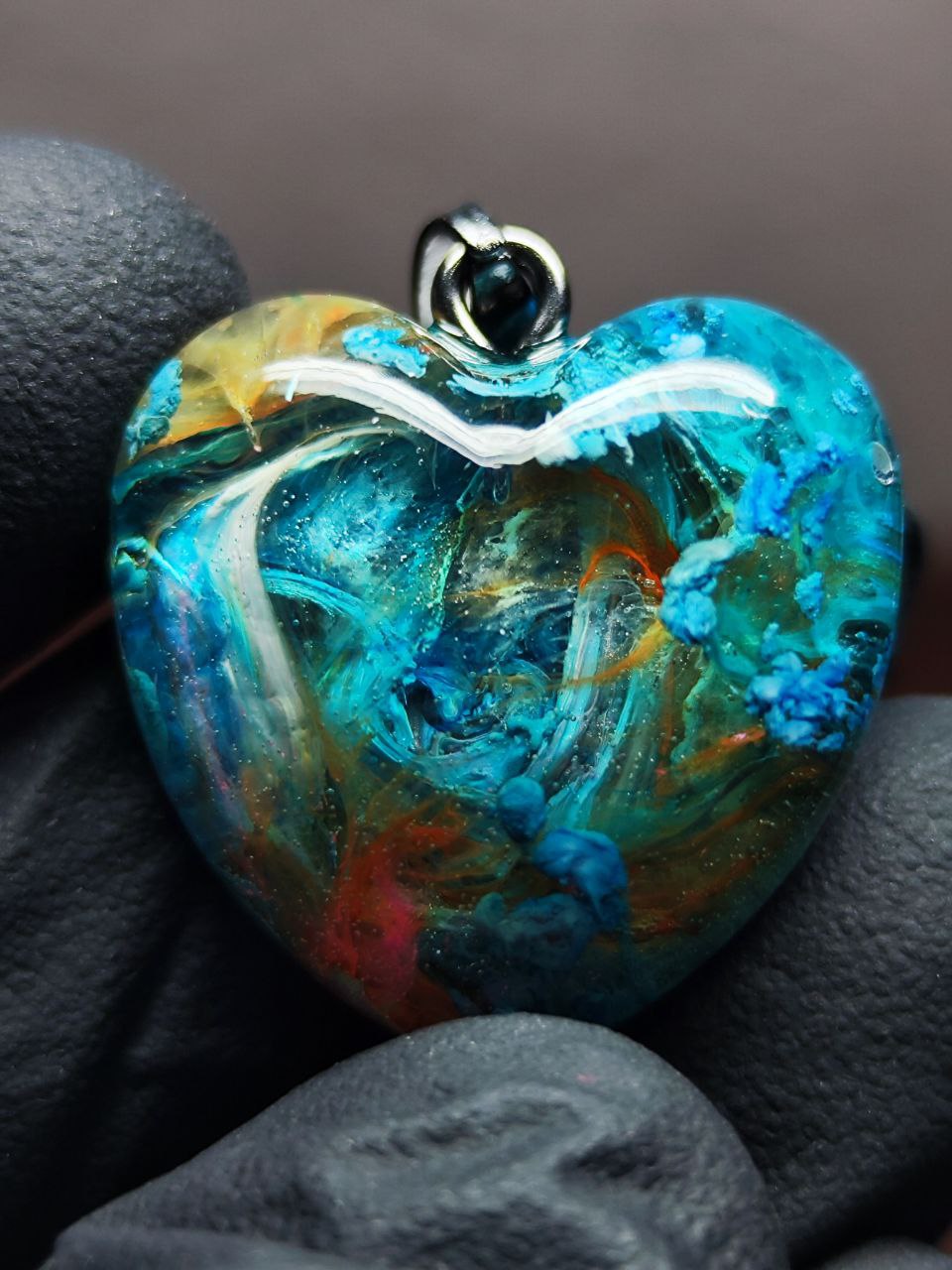 Magic jewelry space hearts made of epoxy resin and alcohol ink.