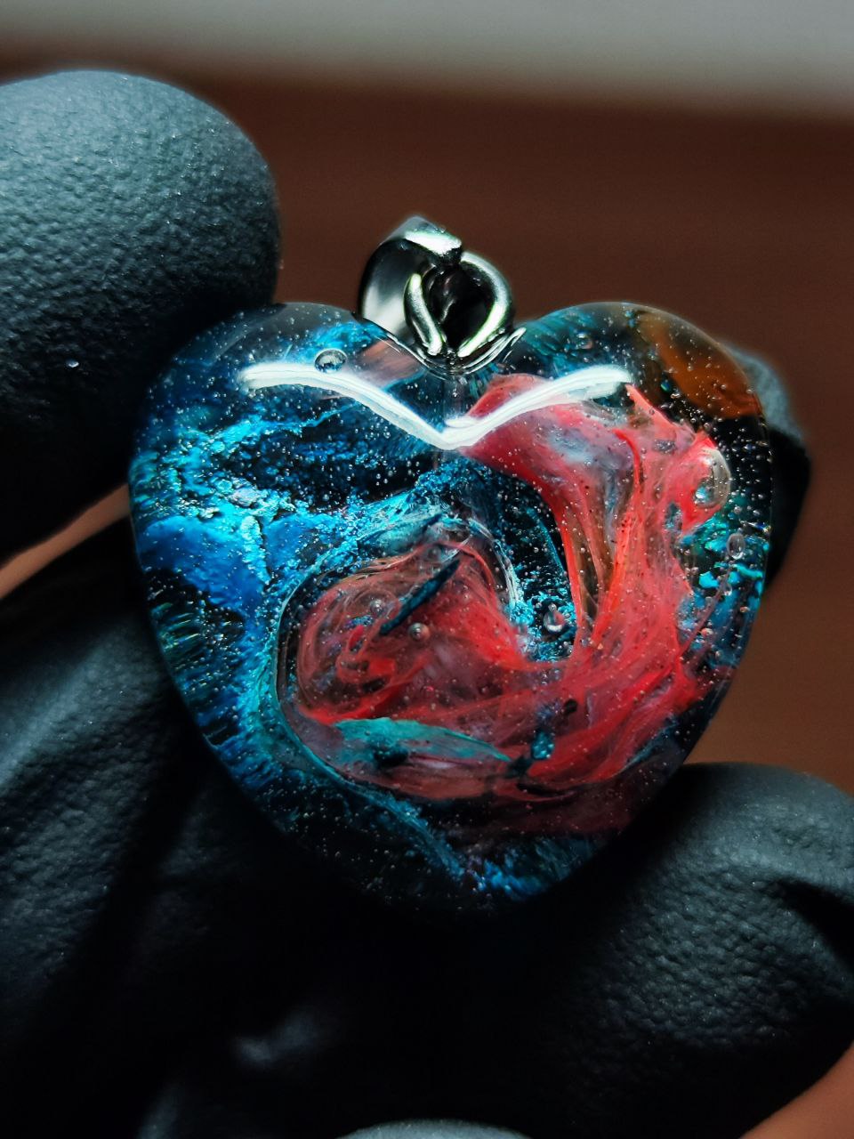 Magic jewelry space hearts made of epoxy resin and alcohol ink.